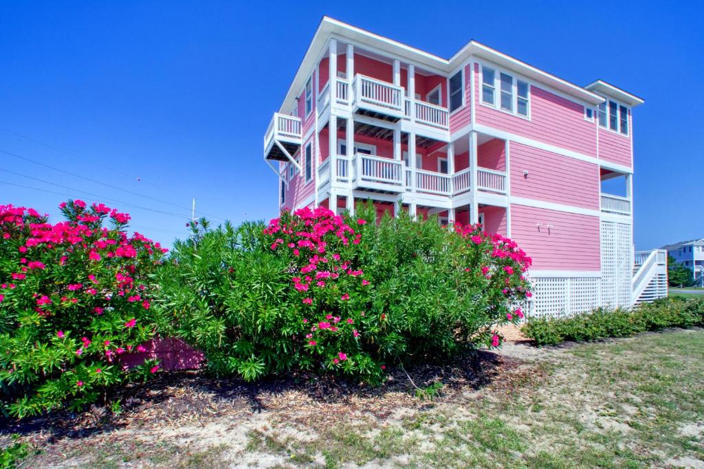a pink house with pink flowers in front of it at San Flamingo 486 in Rodanthe
