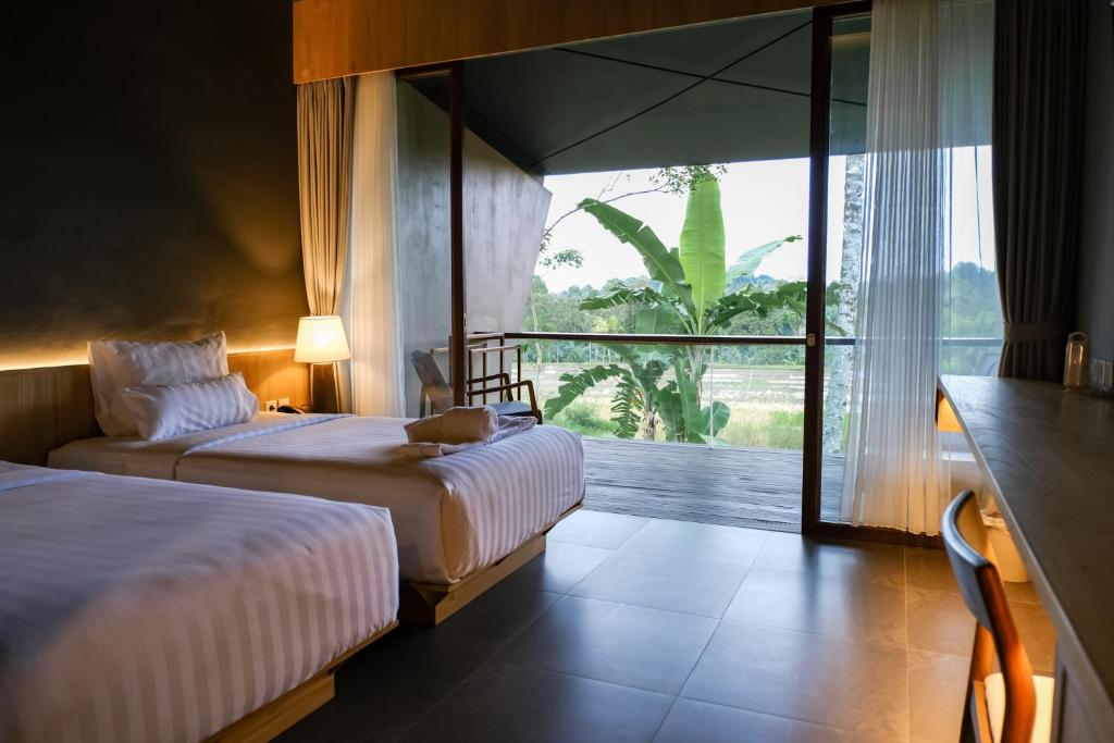 Postel nebo postele na pokoji v ubytování Teras Hotel Ijen Banyuwangi