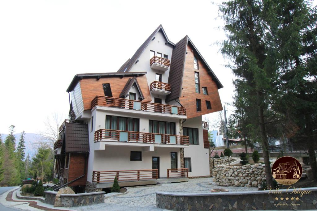 uma casa grande com um telhado de gambrel em Oblique - Forest & Spa em Sinaia