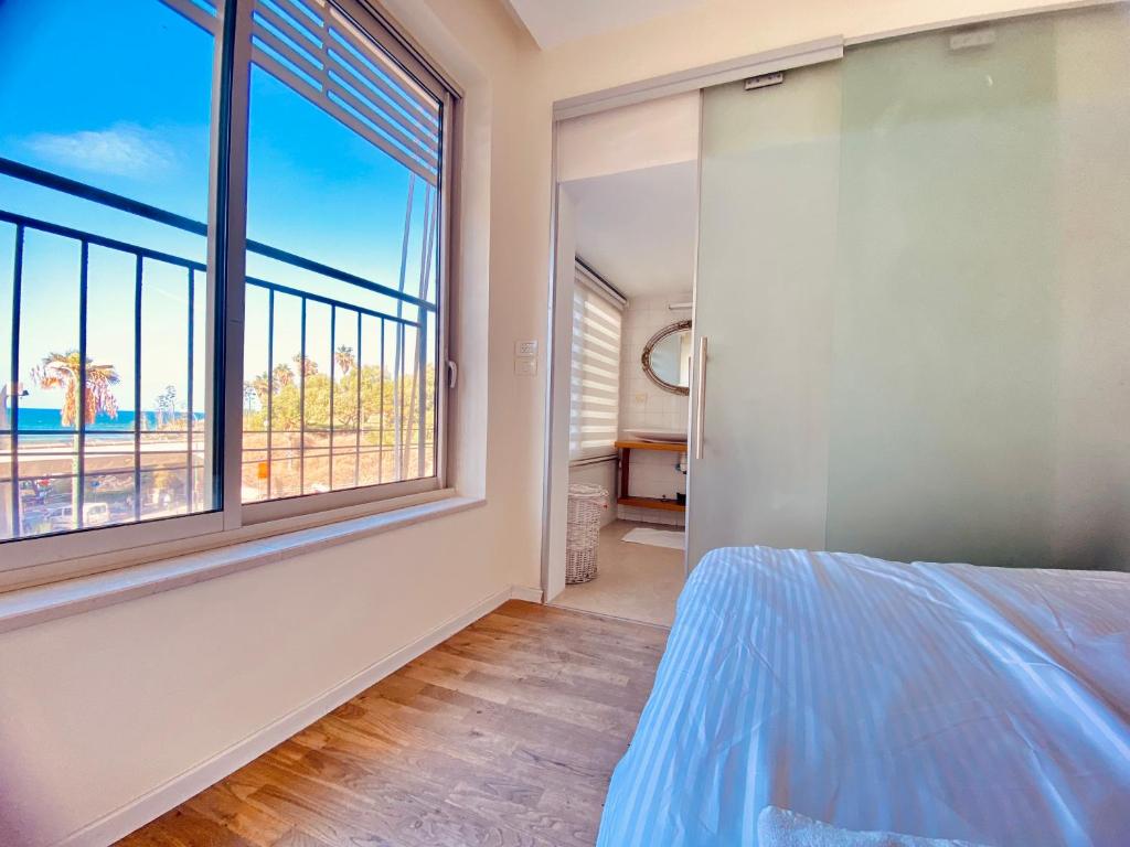 1 dormitorio con cama y ventana grande en White Gordon Beach Apartment, en Tel Aviv