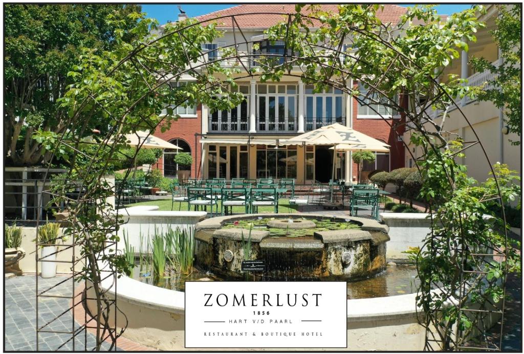 a garden with a fountain in front of a building at Zomerlust Boutique Hotel in Paarl