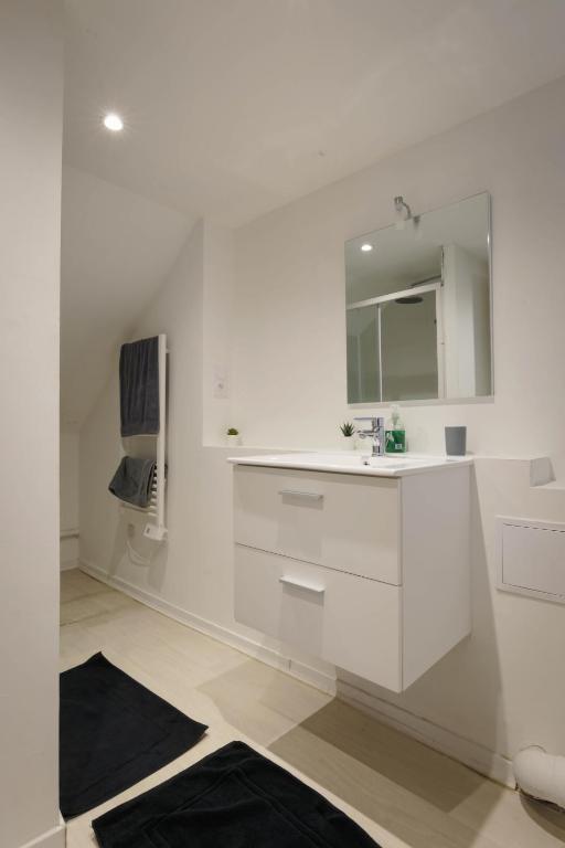 a white bathroom with a sink and a mirror at Studio neuf cosy La flèche in La Flèche
