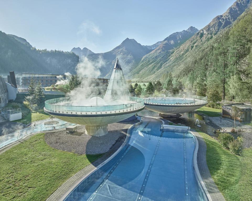 un complejo con una piscina con una fuente en Aqua Dome 4 Sterne Superior Hotel & Tirol Therme Längenfeld, en Längenfeld