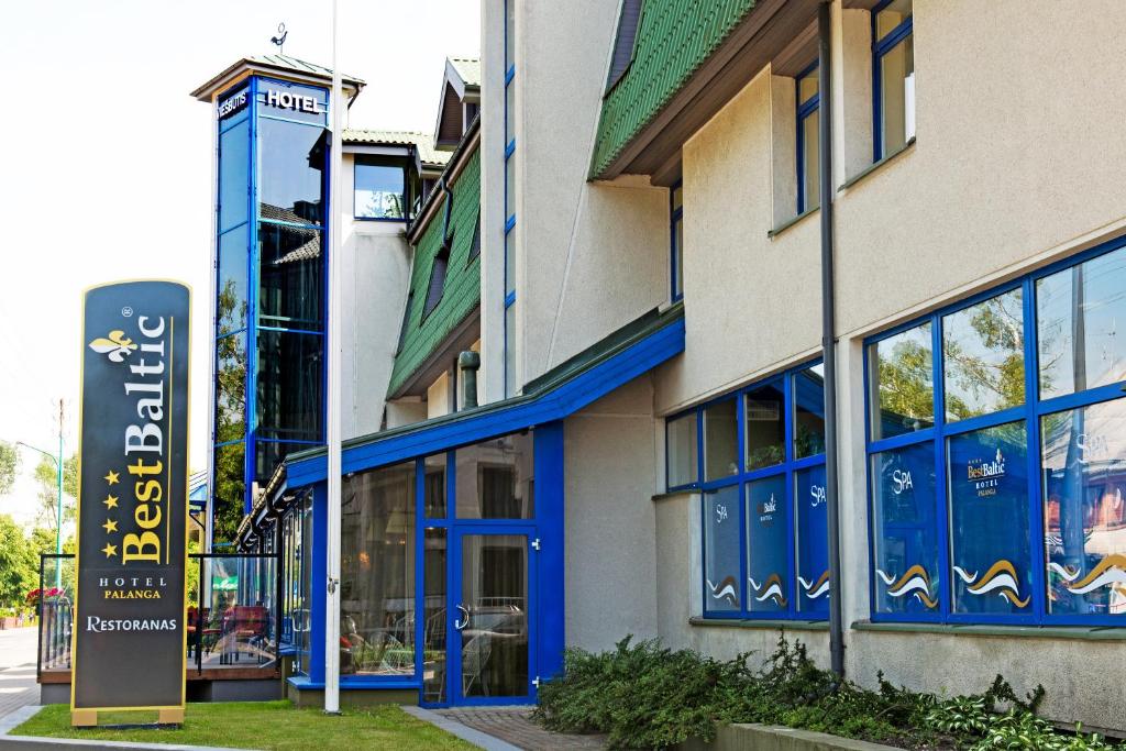 a building with blue trim and a sign in front of it at Best Baltic Hotel Palanga in Palanga