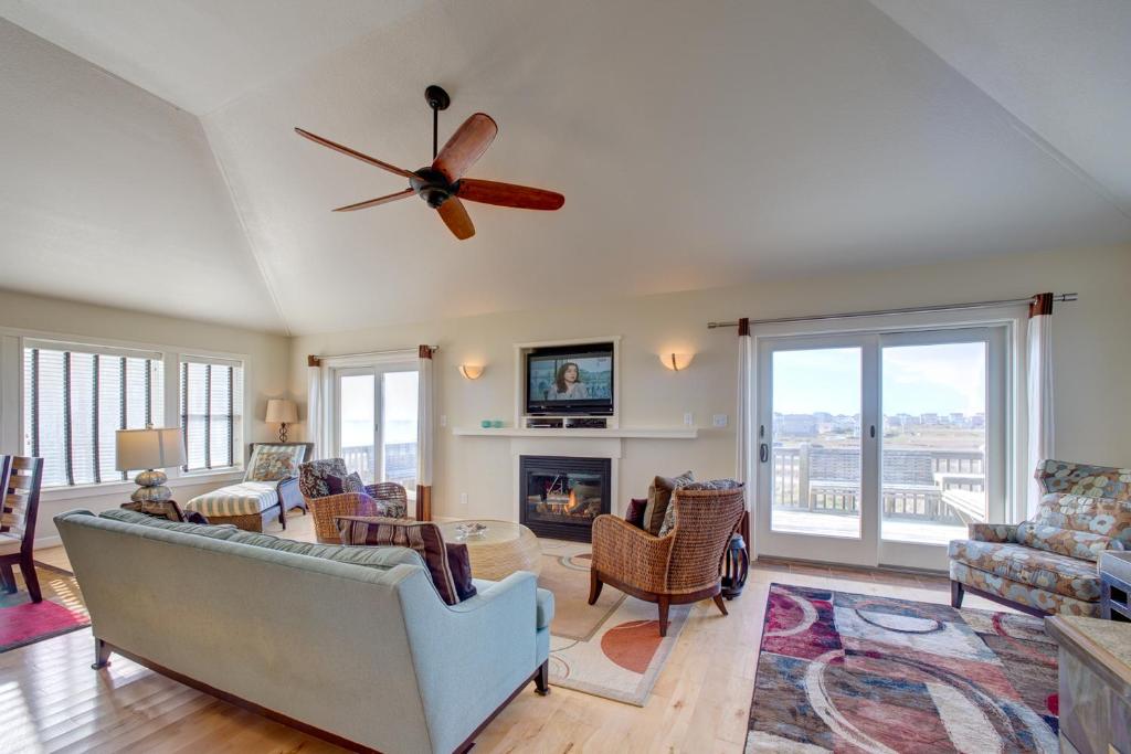 a living room with a couch and a ceiling fan at Gone Coastal 139 in Rodanthe