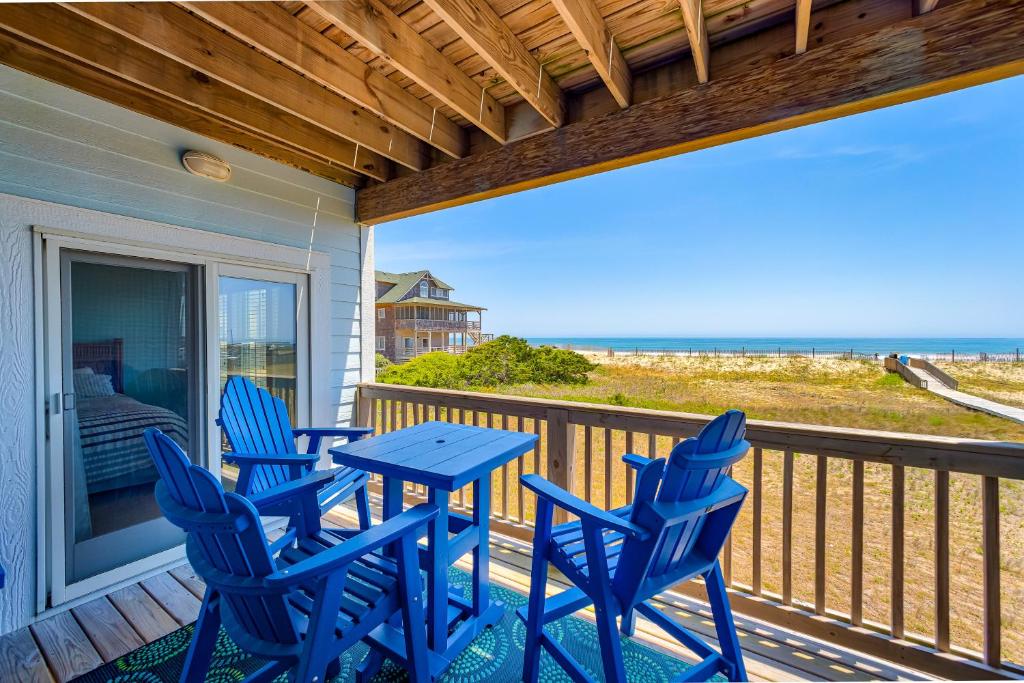a patio with blue chairs and a table on a deck at Seas the Day 991 RR in Rodanthe