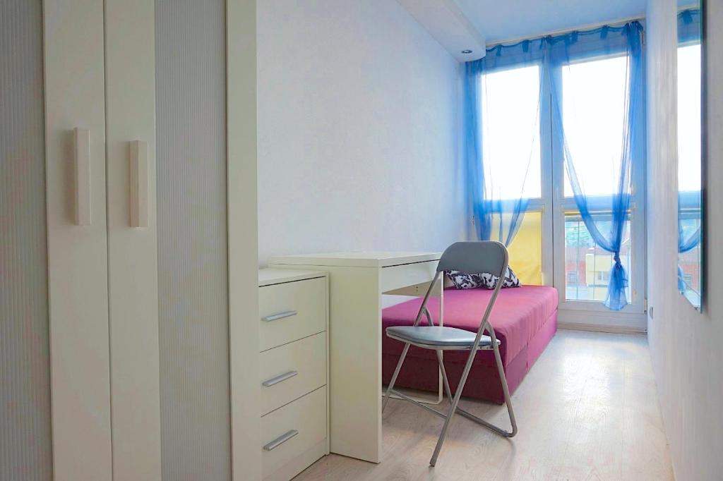 a bedroom with a pink bed and a desk and a chair at Noclegi - ul Śliczna in Wrocław