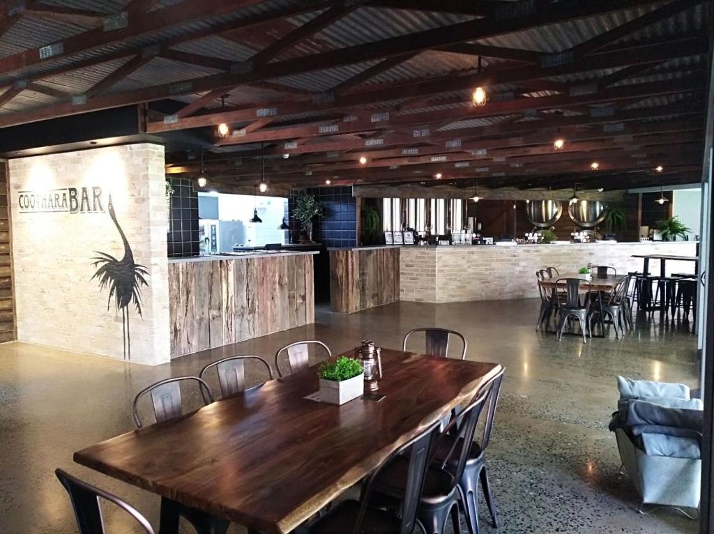una sala da pranzo con tavolo e sedie in legno di Habitat Noosa a Cootharaba