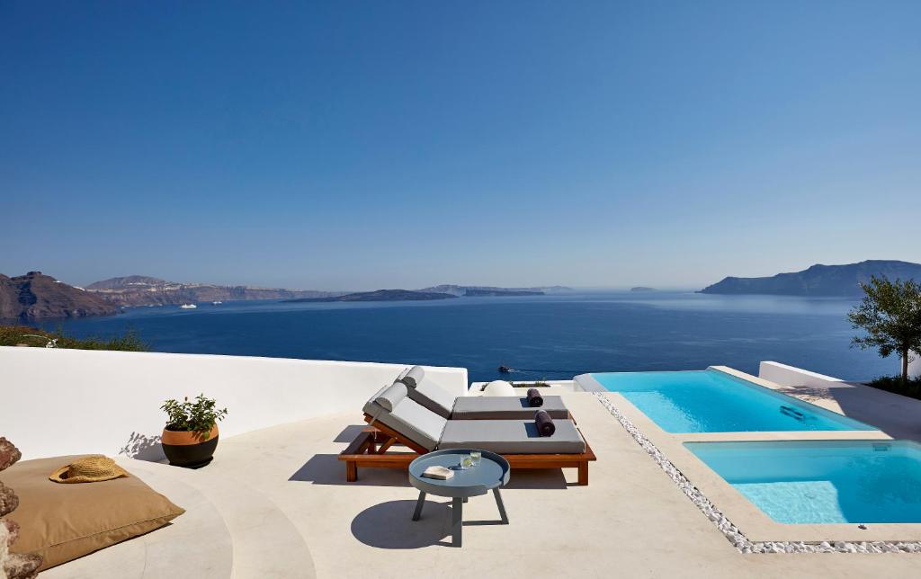 a swimming pool with a view of the ocean at Amaya Selection of Villas in Oia
