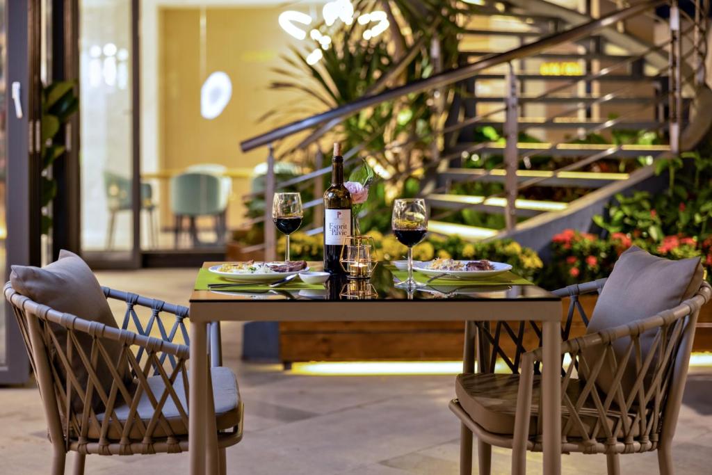 Marco Polo Hotel في بنوم بنه: طاولة مع كرسيين وكؤوس للنبيذ