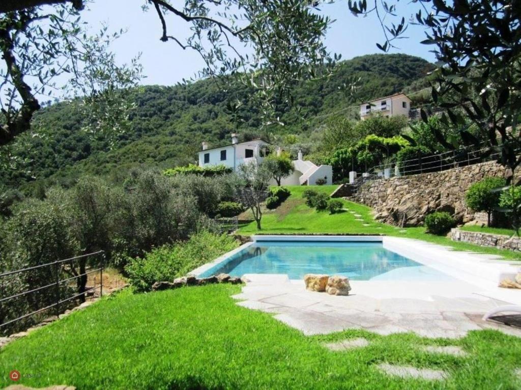 a swimming pool in the grass with a house in the background at Villa Dolcina luxury property in Santa Margherita Ligure in San Lorenzo della Costa