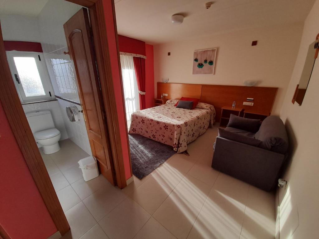 1 dormitorio con 1 cama y 1 sofá en una habitación en Hotel Valdoviño, en Valdoviño