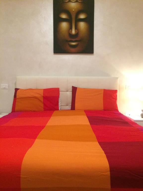 Un dormitorio con una colorida cama con una cara en la pared en Mechai Boatto Tumpat, en Marghera