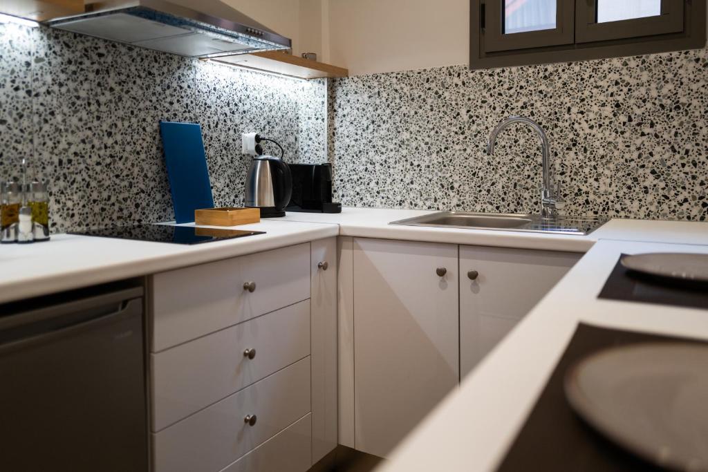 a kitchen with white cabinets and a sink at Vagabond Guesthouse in Athens