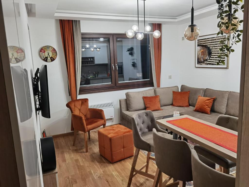 ein Wohnzimmer mit einem Sofa und einem Tisch in der Unterkunft Zlatibor apartman 34 Wellness&Spa in Zlatibor