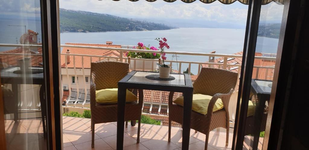 una mesa en un balcón con vistas al agua en Apartman JASNA, en Opatija