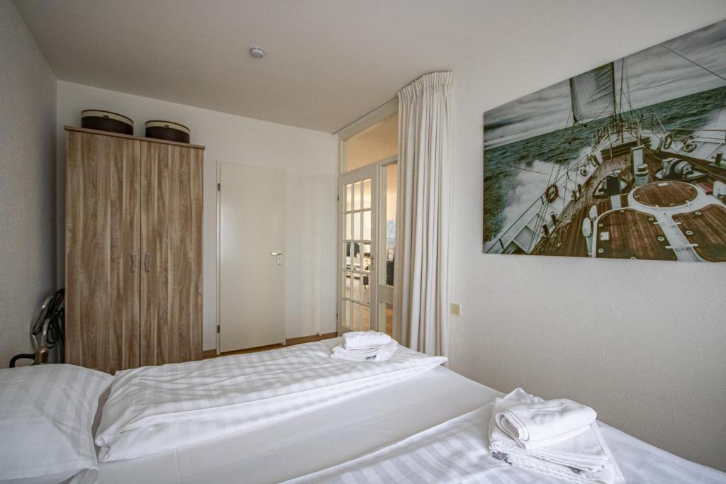 een slaapkamer met 2 bedden en een schilderij aan de muur bij Perfect Stay Holiday, Seadream in Egmond aan Zee