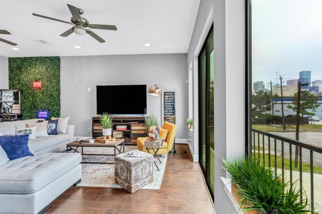 uma sala de estar com um sofá e uma televisão em Modern, Houston Inspired House with Best Views of Downtown! - Less than 1 mile to Eado Midtown Bars home em Houston