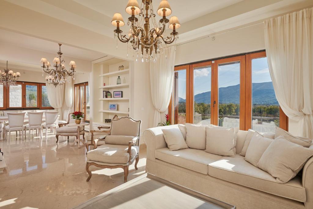 a living room with a white couch and a chandelier at Villa Lovorno in Arbanasi