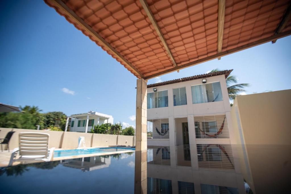 a house with a swimming pool and a building at Casa Beira mar enseada dos golfinhos- Itamaracá in Jaguaribe