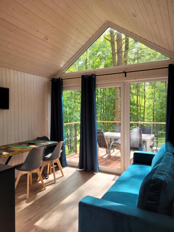 a living room with a blue couch and a table at Przystań Narie in Kretowiny