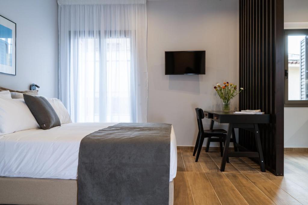 a bedroom with a bed and a desk and a television at Vagabond Guesthouse in Athens
