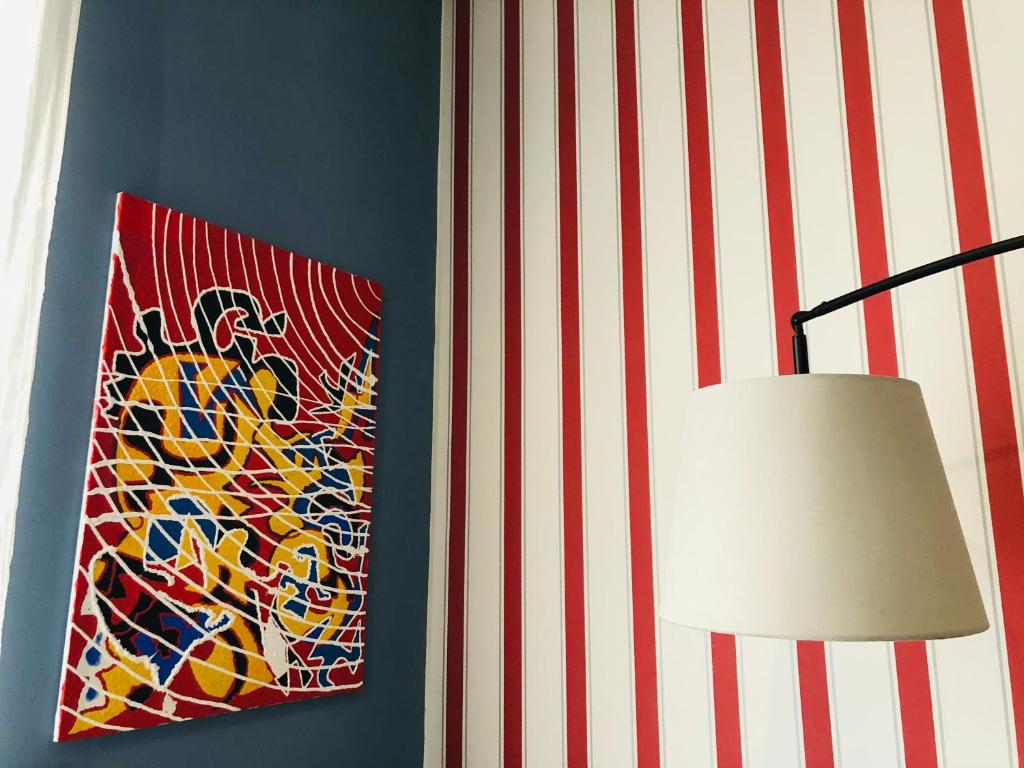 a painting is hanging on a wall next to a lamp at Residenza Avogadro in Turin