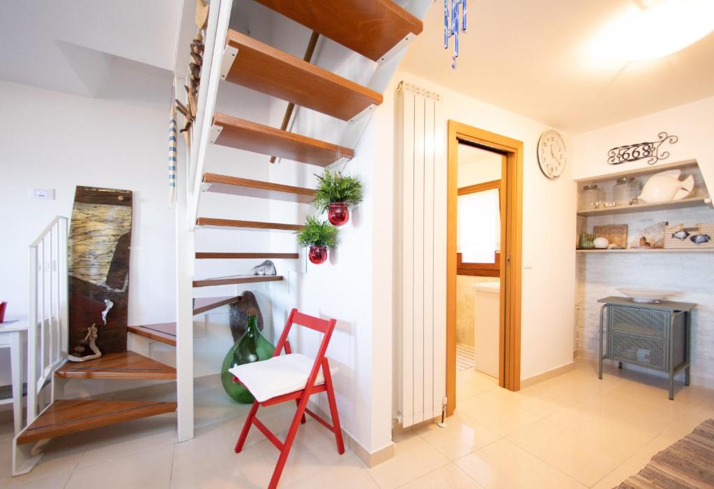 a living room with a staircase and a chair at Dimora Rubino - Isola di Pellestrina Ve in Pellestrina