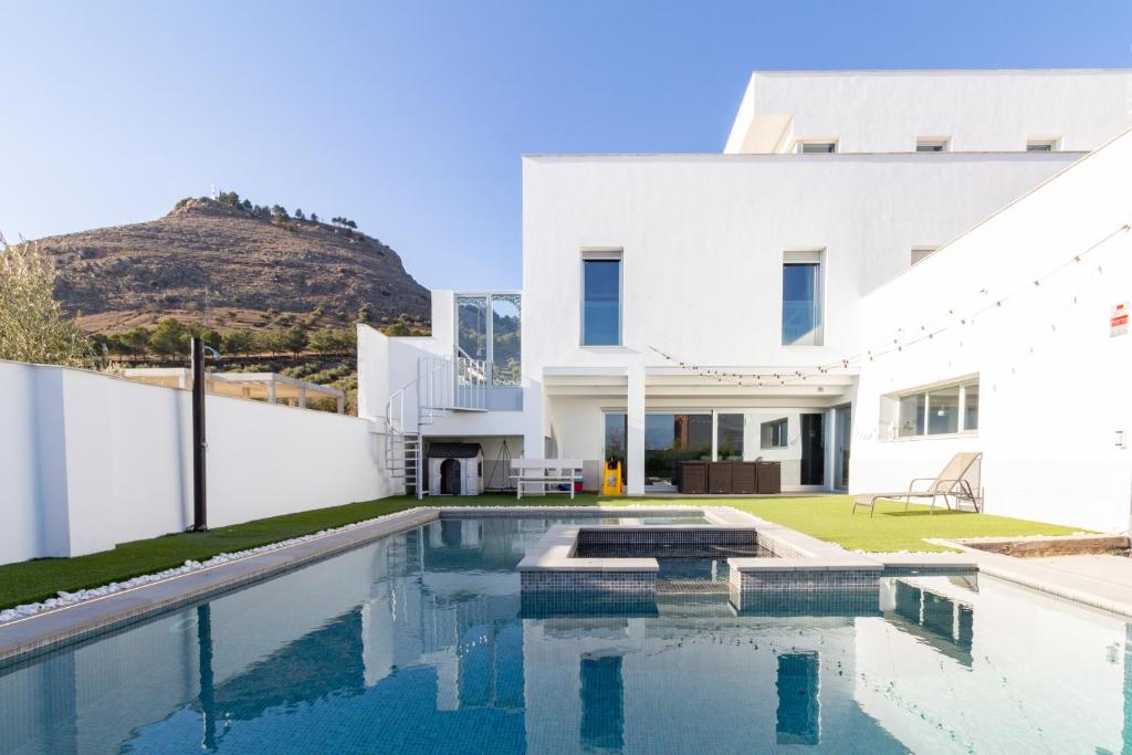 uma casa branca com uma piscina em frente em Casa vista alegre em Atarfe