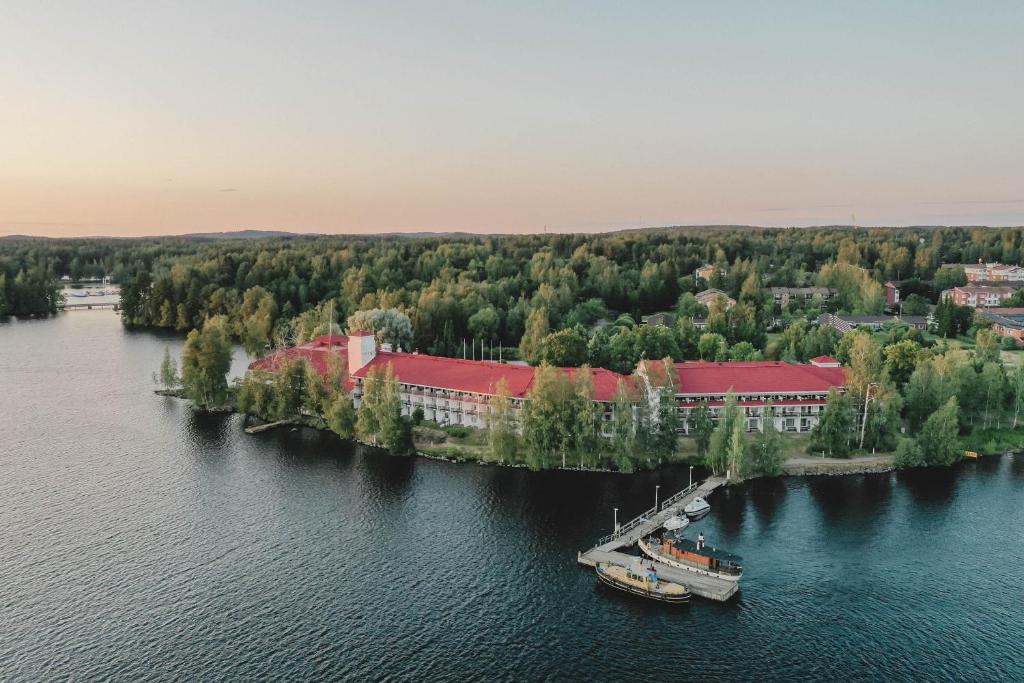 a boat is docked on an island in the water at Hotel Kumpeli Spa in Heinola
