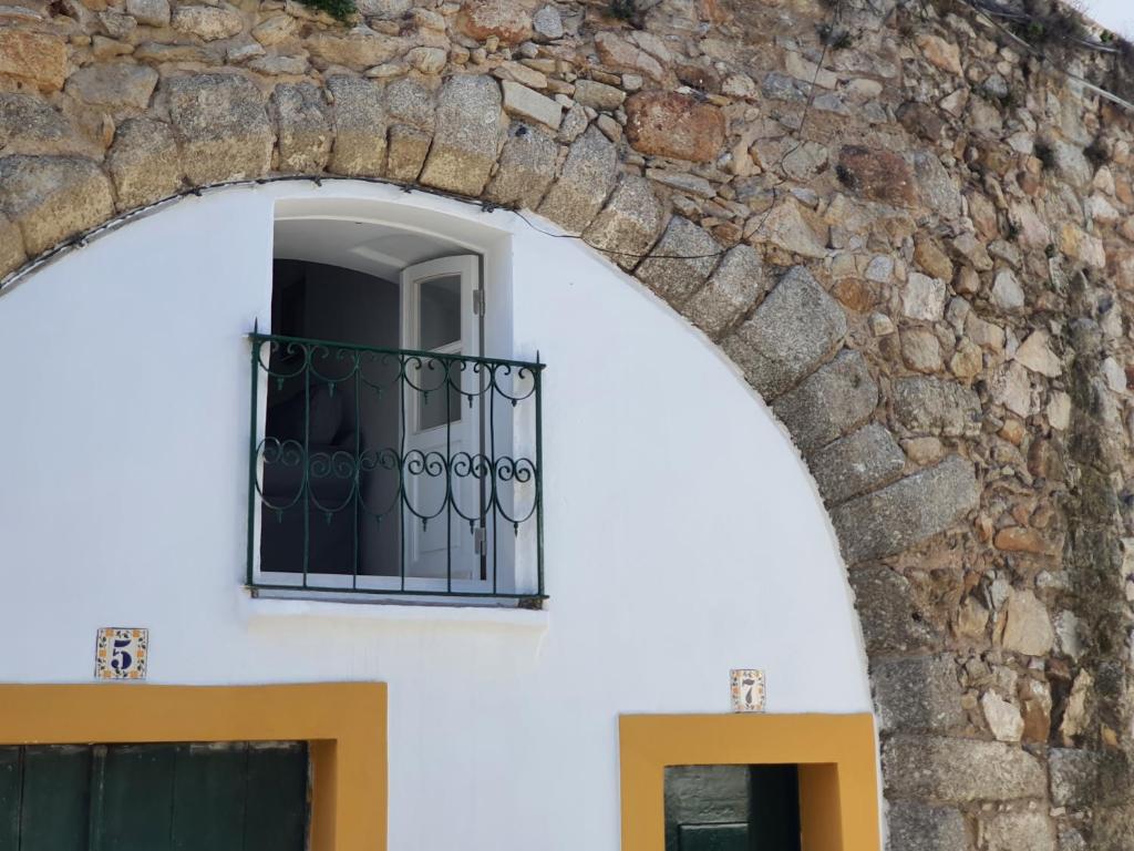 Casa do Salvador I في ايفورا: نافذة مبنى ابيض بجدار حجري