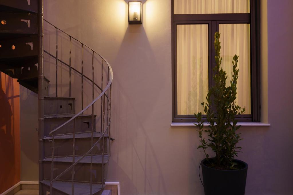 a staircase with a potted plant next to a window at Vagabond Guesthouse in Athens