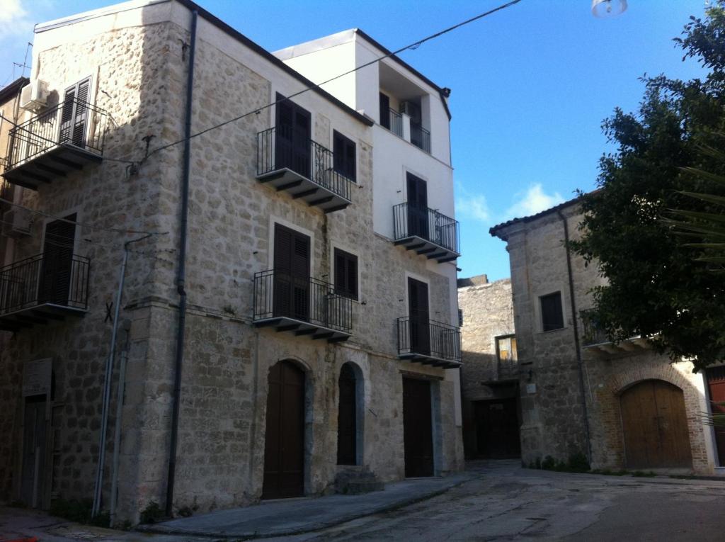 - un vieux bâtiment en pierre avec balcon dans une rue dans l'établissement Casa Natia, à Favara