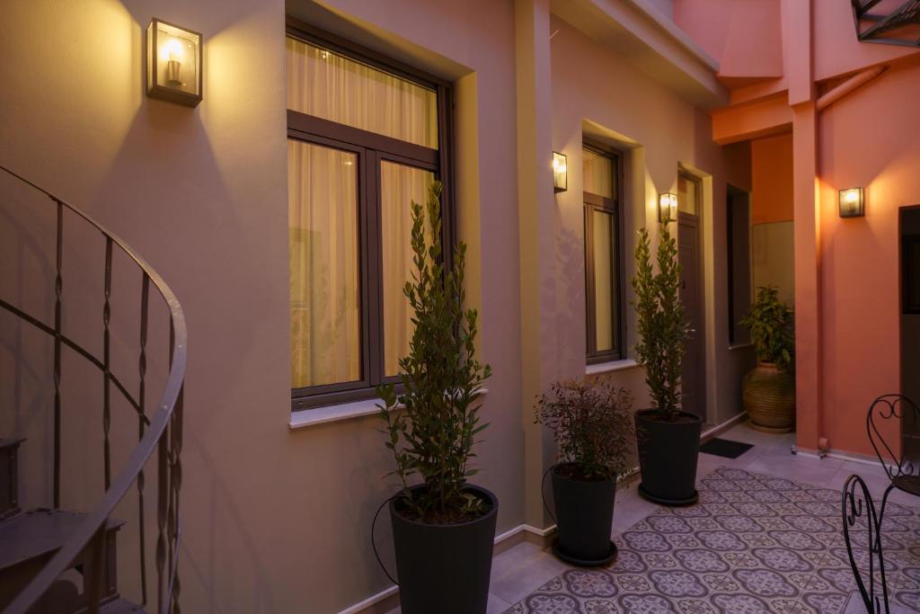 a hallway with three potted plants on the side of a building at GREA Ardittos in Athens