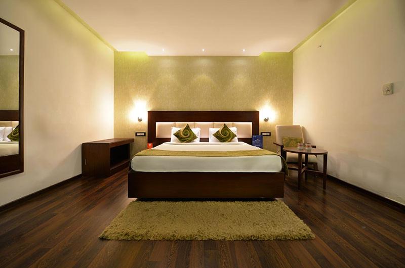 ハイデラバードにあるTabla Pride Hotels & Spaのベッドルーム(大型ベッド1台、鏡付)