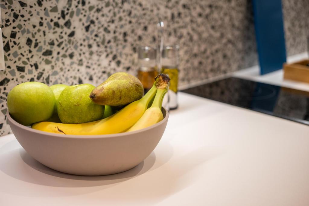 a bowl of fruit on a counter with bananas and pears at Vagabond Guesthouse in Athens