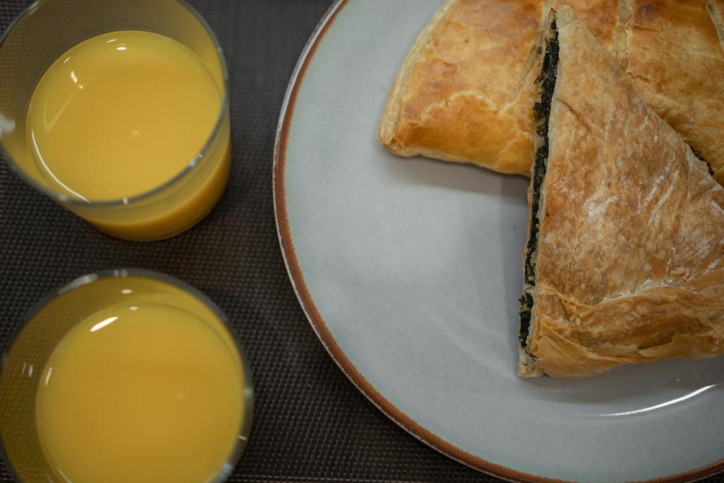a plate with a sandwich and a glass of orange juice at Vagabond Guesthouse in Athens