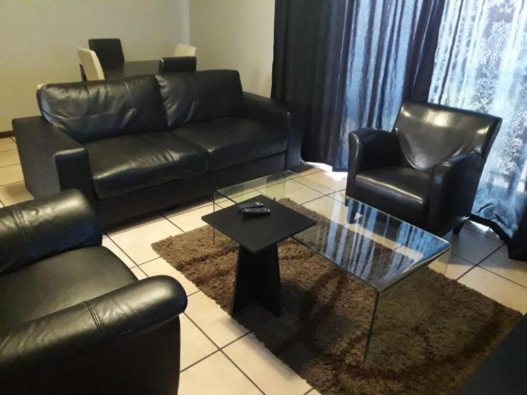 sala de estar con muebles de cuero y mesa de centro en Two Bedrooms at CASA MIA-Katode Street-in ANKAZIMIA HOUSE, en Roodepoort