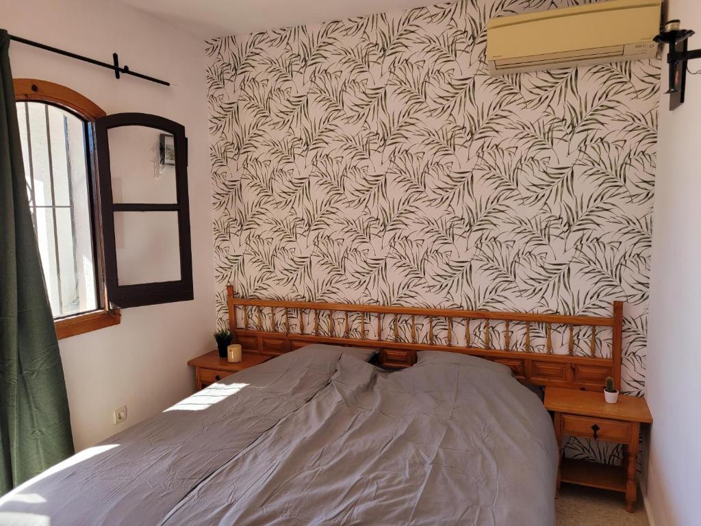 sypialnia z łóżkiem i ścianą z tapetą w obiekcie Apartamento de lujo Nerja w mieście Nerja