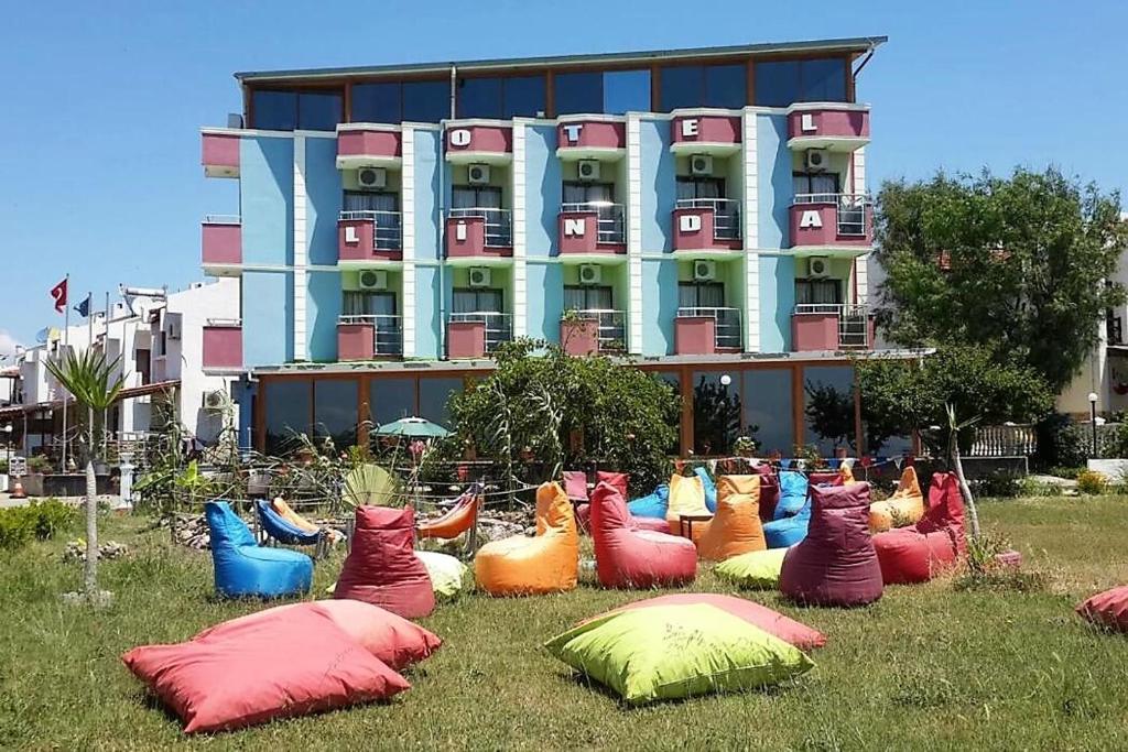 un grupo de almohadas coloridas en la hierba frente a un edificio en Linda Butik Otel Gümüldür, en Izmir