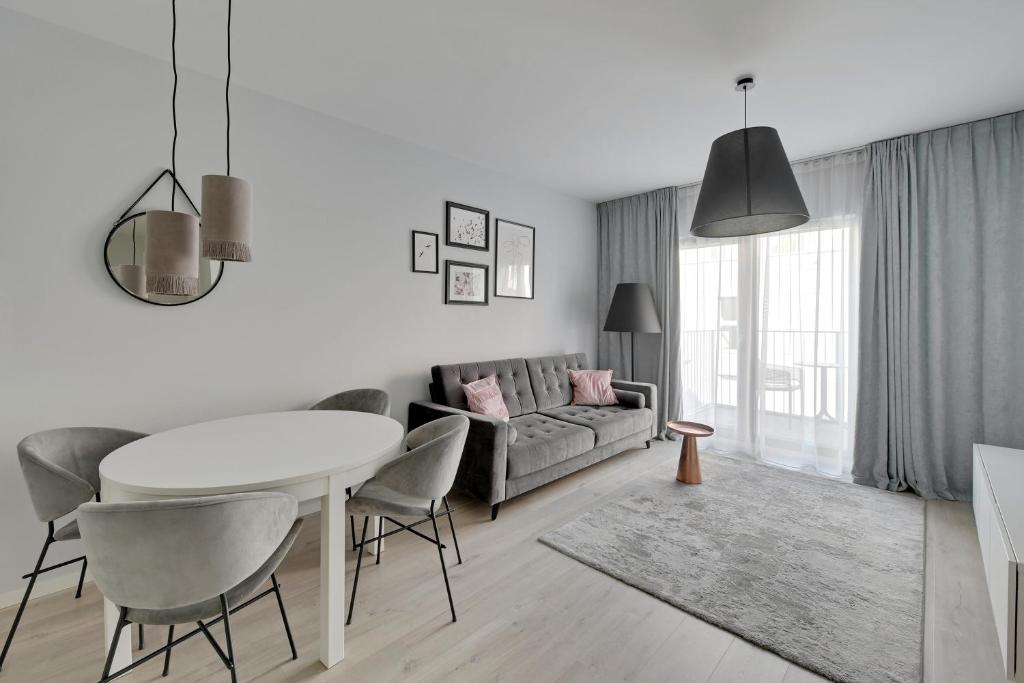 a living room with a table and a couch at Comfort Apartments Grano Residence in Gdańsk