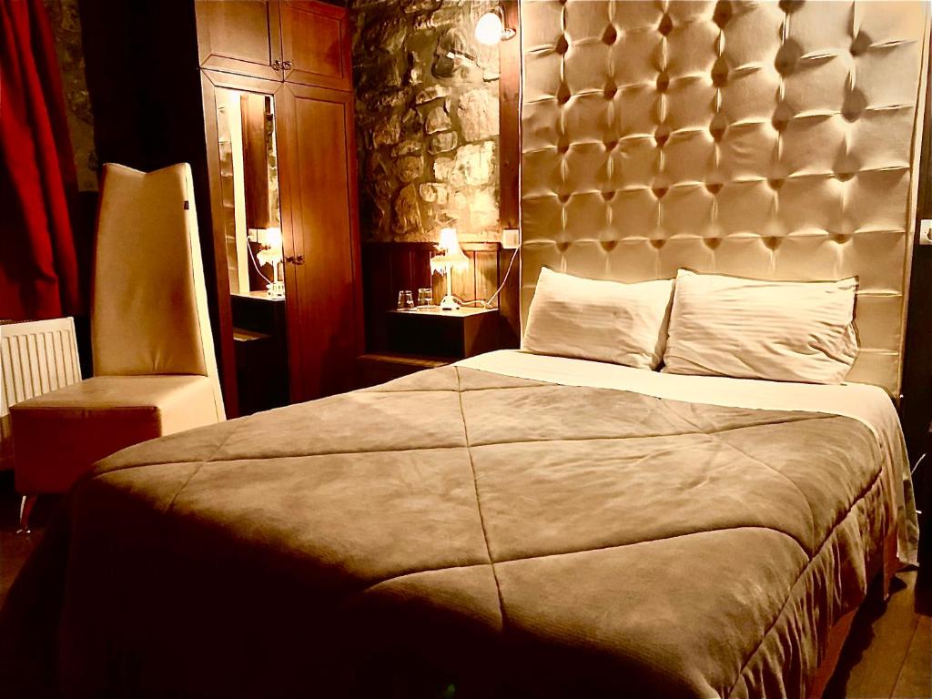 a bedroom with a large bed with a large headboard at Chalet Asteras tou Vorra in Palaios Agios Athanasios