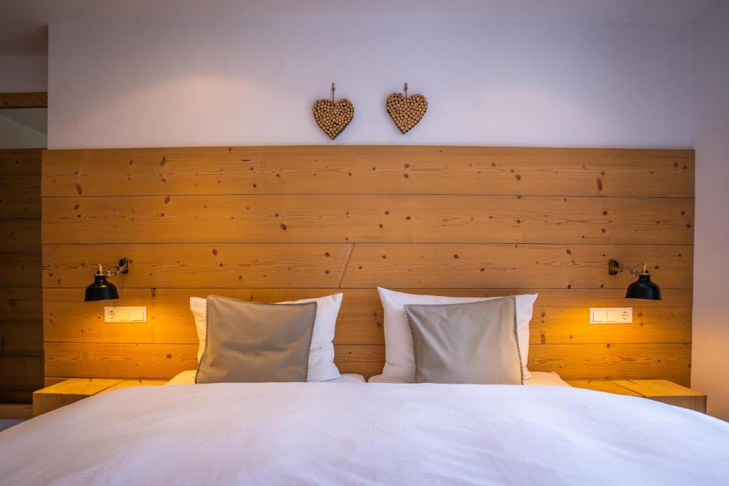 a bedroom with a large white bed with two pillows at MINAROSO appartements am badeparadies -ehemalig Kaltenbachs Appartements in Titisee-Neustadt