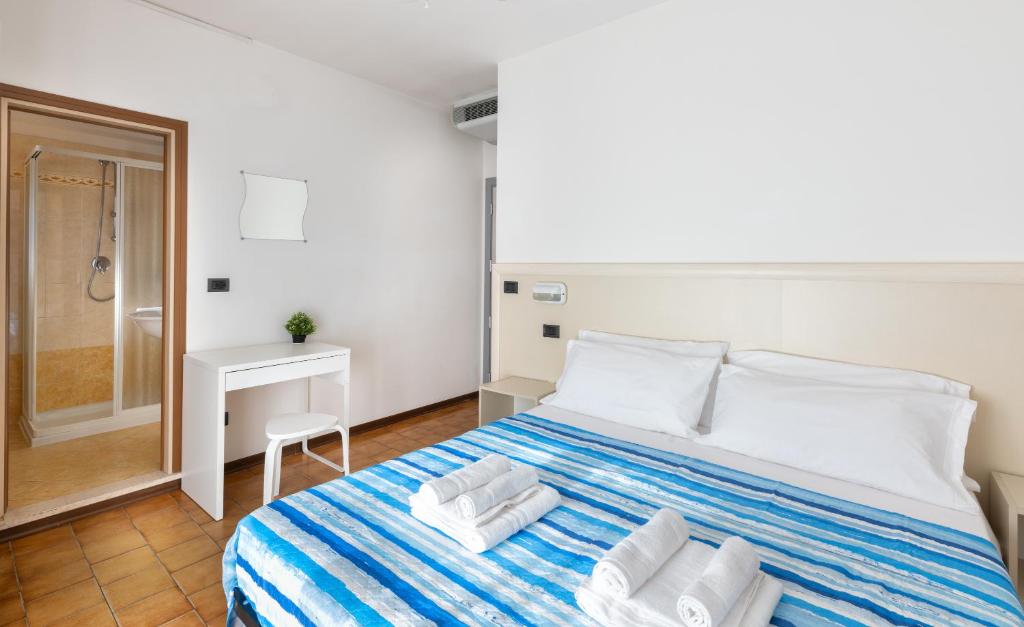 a bedroom with a large bed with towels on it at Hotel Mignon Riccione Fronte Mare in Riccione