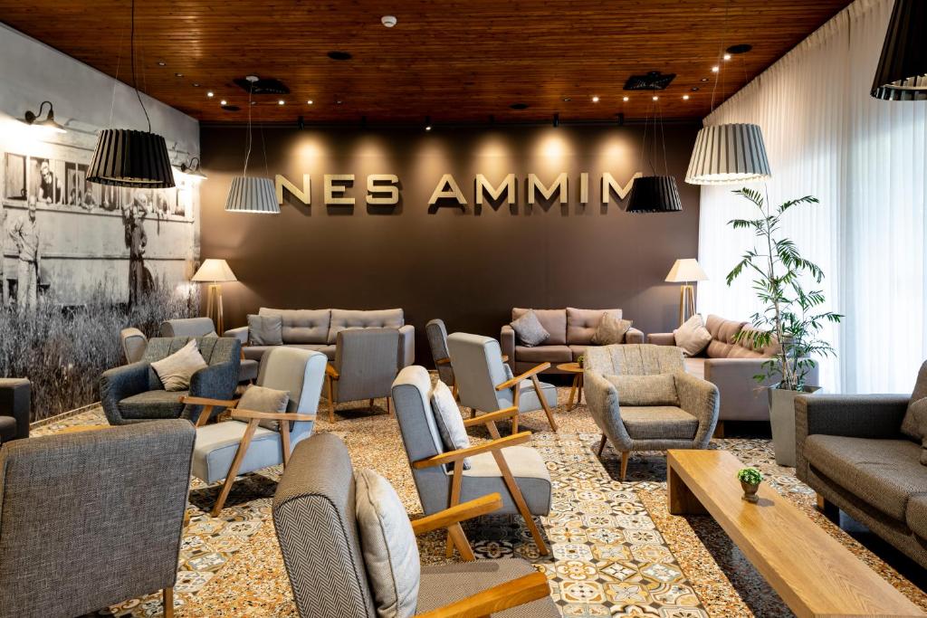 a waiting room with couches and chairs and a nes amnium sign at Nes Ammim Hotel in Nes Ammim