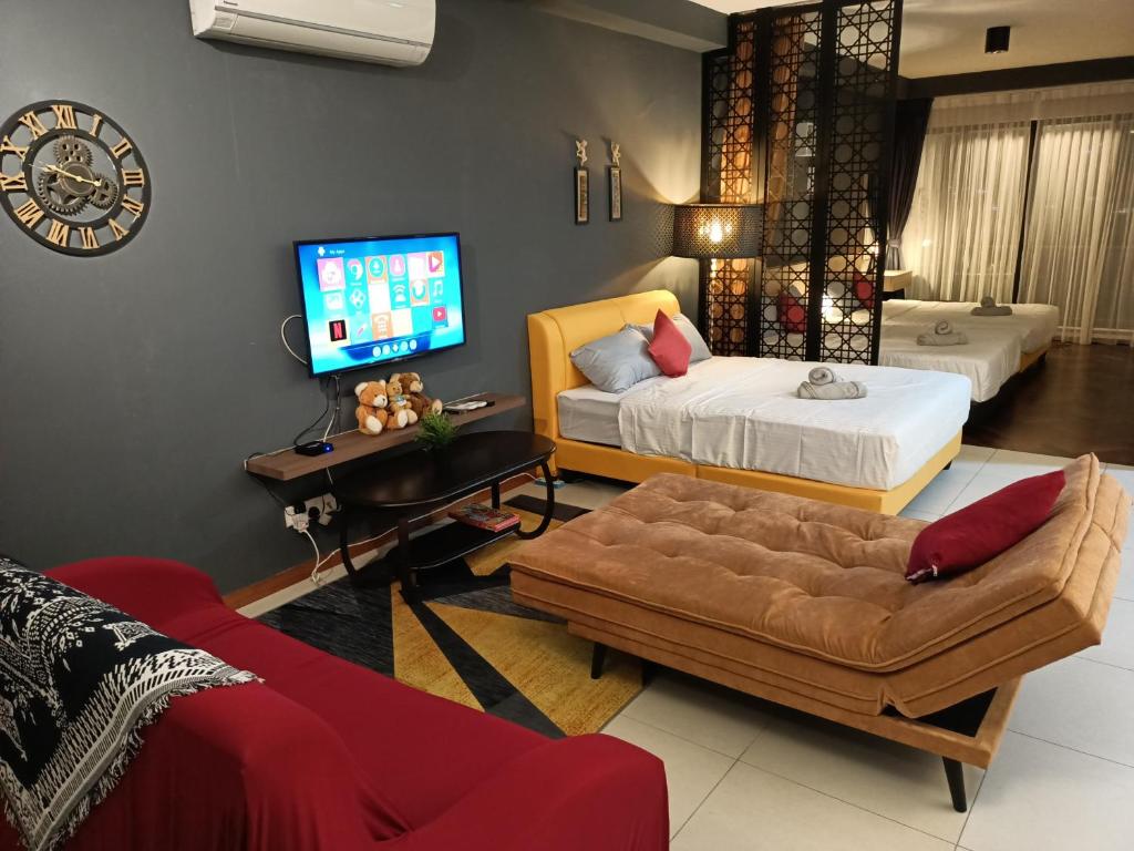 salon z 2 łóżkami, kanapą i telewizorem w obiekcie cozy seaview 5 studio apartment w mieście Tanjong Tokong