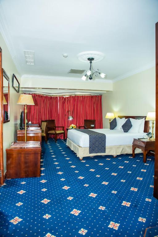 um quarto de hotel com uma cama e uma secretária em Weston Hotel em Nairobi