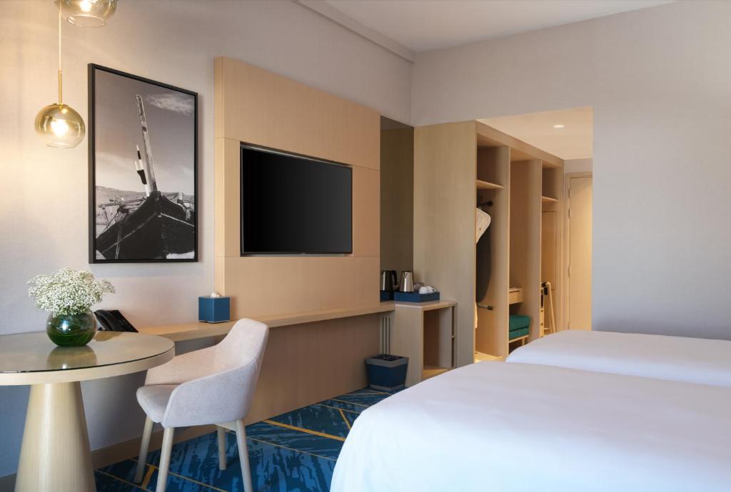 Postel nebo postele na pokoji v ubytování Maani Muscat Hotel & Suites