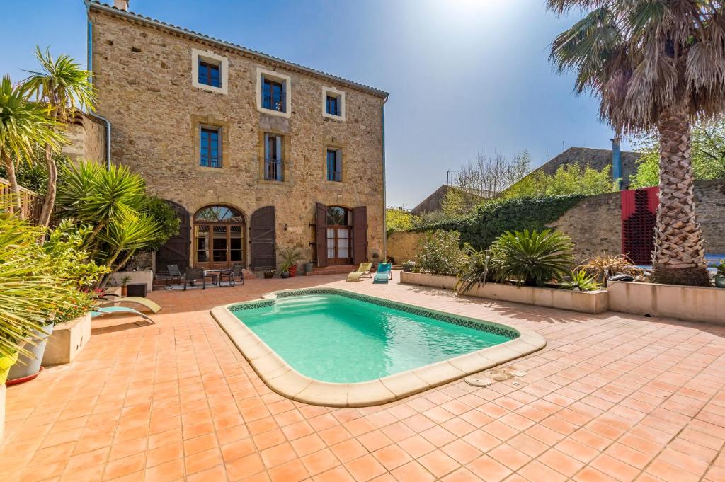 einem Pool vor einem Gebäude in der Unterkunft Maison Dix Chambres d'hôtes in Néffiès