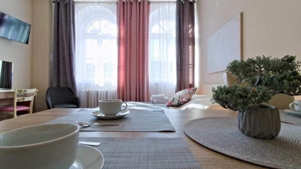 a dining room table with cups and dishes on it at 1868 Starke & Hoffmann by LC pokoje & apartamenty in Jelenia Góra